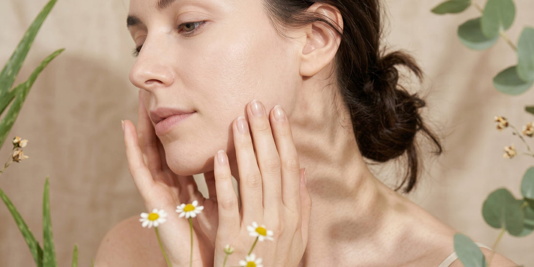Woman touching her face with a natural background of plants and flowers.